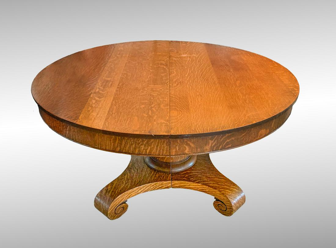 QUARTER SAWN OAK TABLE WITH LEAF: QUARTER SAWN OAK TABLE WITH LEAF: Round Oak dining table with locking mechanism, for leaf, at underside. Without leaf. Approx. 28.75" h x 54" Dia. With leaf. 28.75" h x 63" l x 54" w.