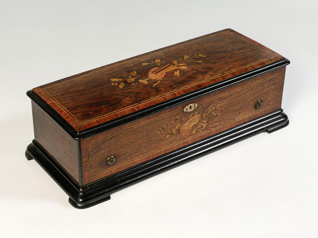 SWISS 6 TUNE CYLINDER MUSIC BOX: SWISS 6 TUNE CYLINDER MUSIC BOX: Single comb music box, having inlaid instrumental & floral motif. Monogrammed, "H. Grate" at tambourine. Approx. 7.25" h x 23.5" l x 10" w.