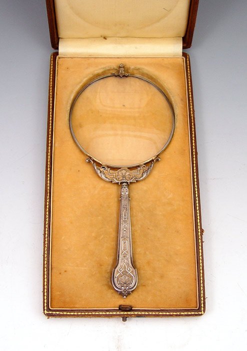 FRENCH STERLING MAGNIFYING GLASS IN PRES. CASE: FRENCH STERLING MAGNIFYING GLASS IN PRESENTATION CASE: Embossed handle and mount. Unidentified French makers hallmark on bezel. 7 3/8'' long. In cloth lined, leather covered, presentation case with ow
