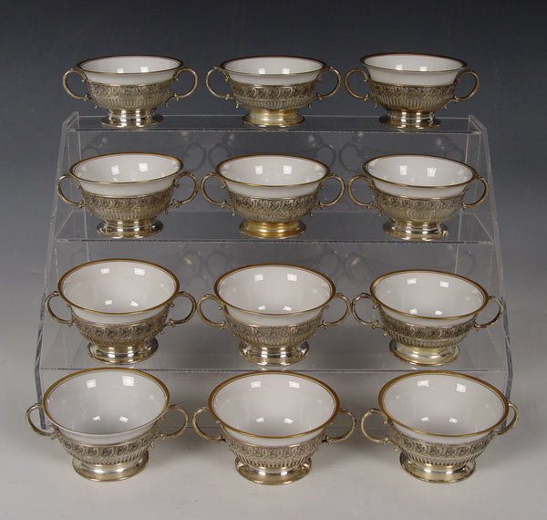 WHITING STERLING CREAM SOUP HOLDERS W/ LIMOGE CUPS: 12 STERLING CREAM SOUP CUP HOLDERS WITH LIMOGES CHINA INSERTS: Whiting sterling reticulated double handle cup holders (One sterling holder is a replacement). Limoges and Bavarian fine china inserts in