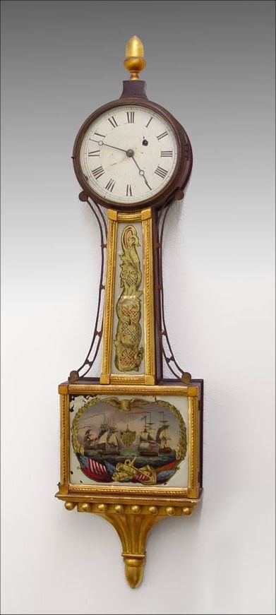 WILLARD ERA PERRY'S VICTORY BANJO CLOCK : WILLARD ERA PERRY'S VICTORY REVERSE PAINTED BANJO CLOCK: Reverse painted battle scene of Admiral Perry's victory with federal eagle, shield, flags, cannons and anchor. Brass adornments on sides of nec
