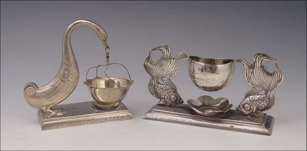 2 PIECE SILVER VIETNAMESE TEA BAG HOLDERS: 2 PIECE SILVER VIETNAMESE TEA BAG HOLDERS: 900 silver teabag holder to include 1) Shape of 2 goldfish with either tail supporting holder, on base. 2 1/" h. x 5" x 1 1/2". 2) Goose holding holder in mo