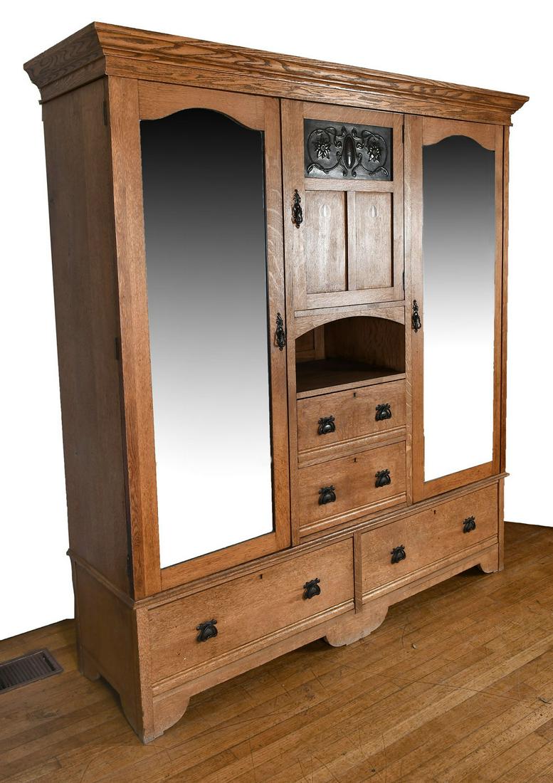 INLAID OAK DOUBLE DOOR ARMOIRE WITH MIRRORS: INLAID OAK DOUBLE DOOR ARMOIRE WITH MIRRORS: 3- door, 4- drawer oak armoire. Center doors have inlaid flowers buds. Approx. 81.25" h x 74.75" l x 21.75" w.