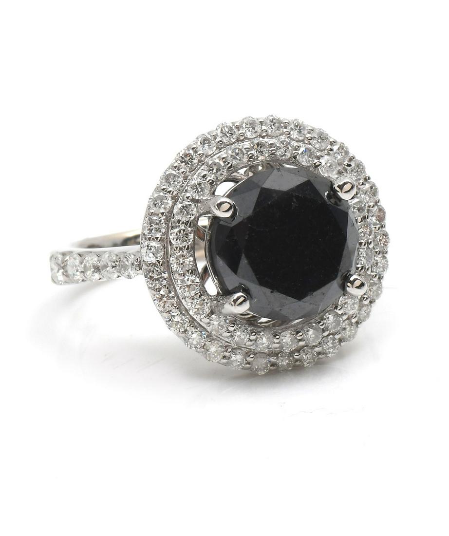 14K BLACK DIAMOND RING: 14K BLACK DIAMOND RING: 4.84CT round brilliant cut black diamond set in 14k white gold surrounded by 64 1.05CT prong set diamonds that drape down the shoulders. Diamonds rated SI2-I1 in clarity and H-
