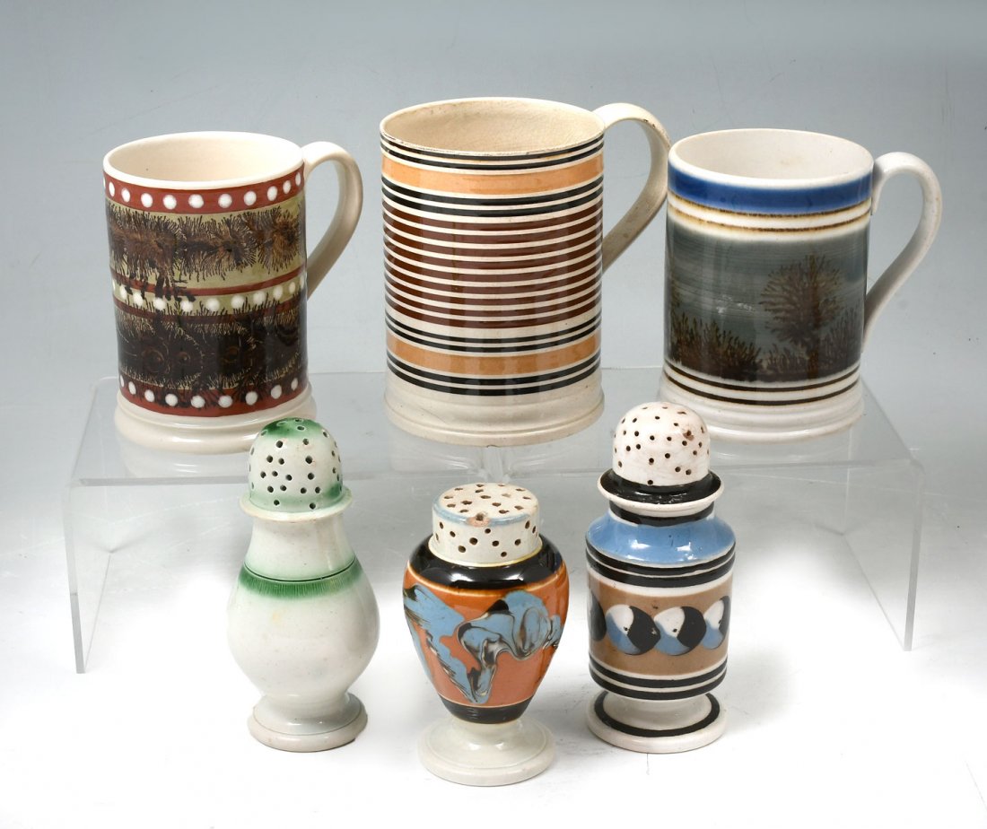 6 PC. MOCHAWARE MUGS & PEPPER POTS: 6 PC. MOCHAWARE MUGS & PEPPER POTS: Comprising; 2- Seaweed pattern mugs, 1- Early striped mug, & 1- Earthworm pattern pepper pot, 1- Cat's eye pepper pot, & 1- Green Leeds pepper pot. Largest Approx. 