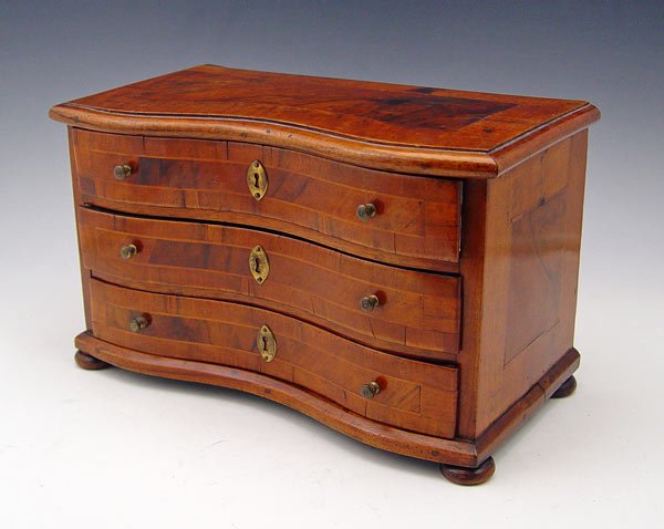 MINIATURE BANDED MAHOGANY CHEST: MINIATURE SERPENTINE FRONT CHEST OF DRAWERS: The details are as fine as the full size. Banded mahogany and string inlay, drawer fronts and top, brass knobs, bun feet. 7'' tall x 12'' x 6''.