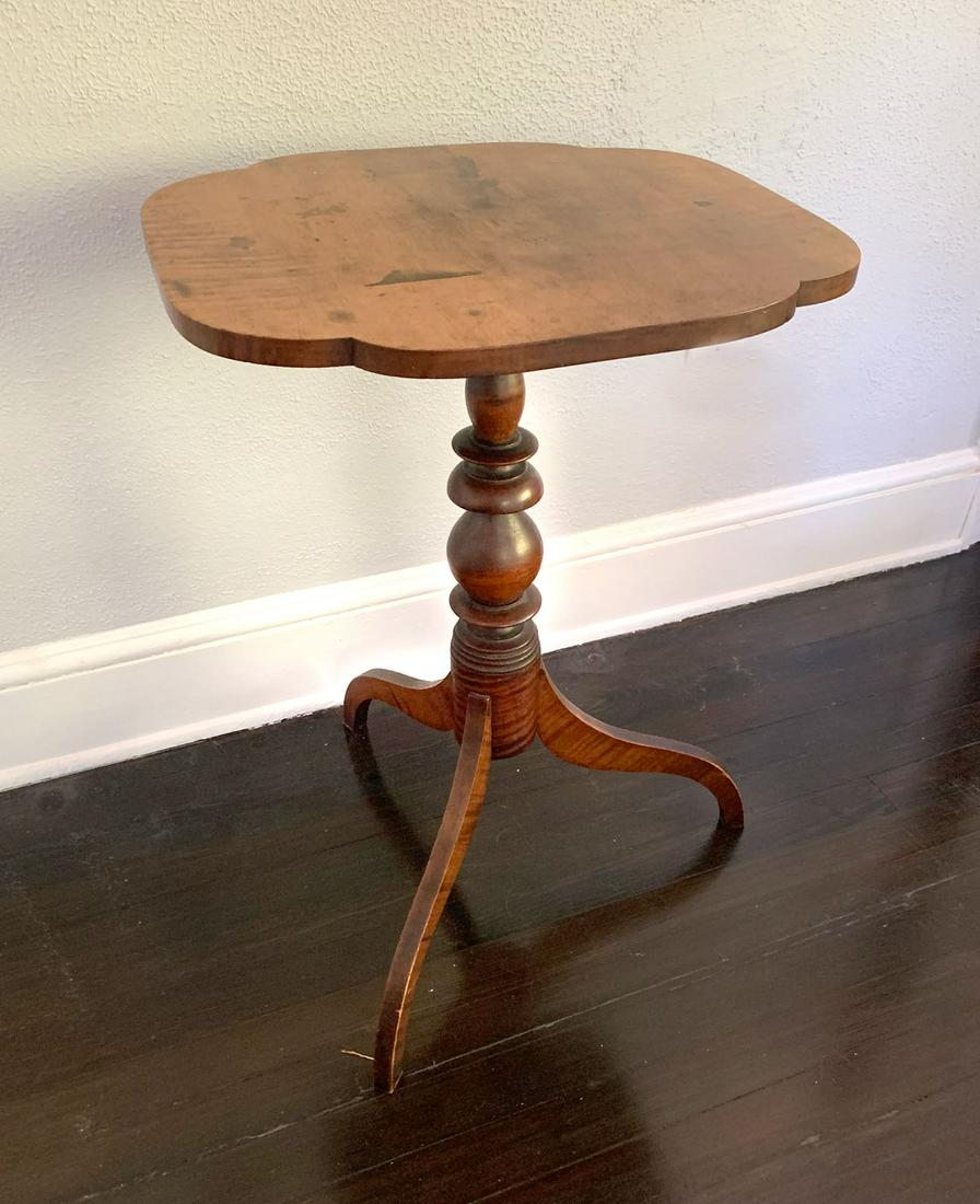 MAPLE CANDLE STAND: TIGER MAPLE CANDLE STAND: American 18th century Tiger Maple stand, having a turned support, with three spider legs. Approx. 29'' h x 20'' l x 17.75'' w.
