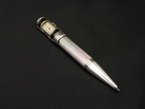 CARTIER STERLING MECHANICAL PENCIL / WATCH: CARTIER ENAMELED STERLING PENCIL / WATCH: Art Deco mechanical sterling pencil with built in Cartier watch. Black enamel bands. Monogrammed HR. The watch is not running. 3 5/8'' length.