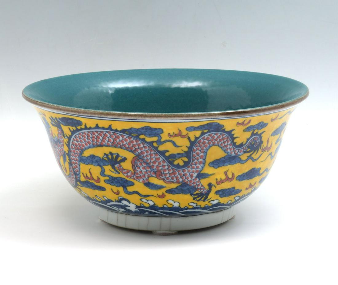 YELLOW GROUND CHINESE DRAGON BOWL: Hand thrown Chinese: YELLOW GROUND CHINESE DRAGON BOWL: Hand thrown Chinese porcelain bowl, having a yellow ground with Dragon amongst stylized Water, Fire, & Clouds. Incised brown mark at underside. Approx. 5'' h x 11'' 