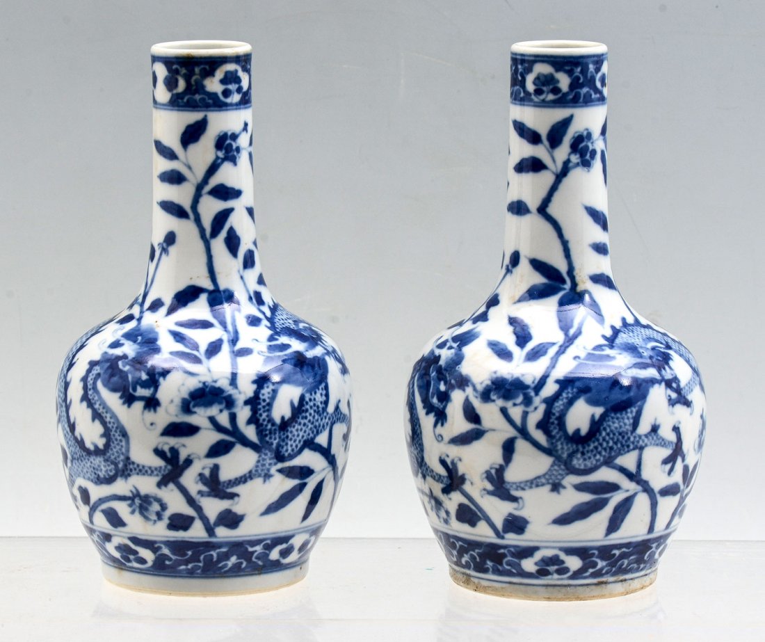 PAIR OF CHINESE BLUE & WHITE DRAGON VASES: PAIR OF CHINESE BLUE & WHITE DRAGON VASES: Pair of Chinese bottle vases, having a floral & foliate motif with Dragons. Underside reveals a blue 4 character Kangxi period make mark. Approx. 7.5" h x 4"