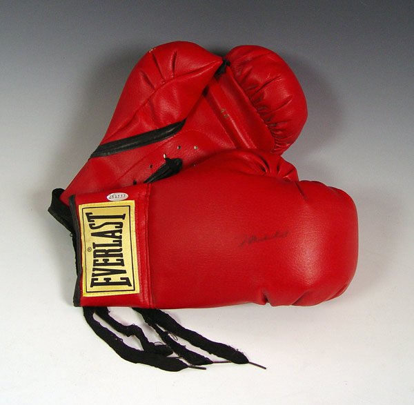 MUHAMMAD ALI AUTOGRAPHED BOXING GLOVES: MUHAMMAD ALI AUTOGRAPHED BOXING GLOVES: 14 oz. red glove signed in blue sharpie. Sold with photo of Ali signing gloves.