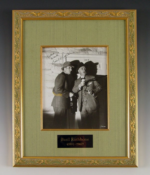 BASIL RATHBONE SHERLOCK HOLMES SIGNED PHOTOGRAPH: BASIL RATHBONE ''SHERLOCK HOLMES'' SIGNED PHOTOGRAPH: Signed ''Best Wishes Basil Rathbone'' in ink on black & white studio still of Rathbone & Nigel Bruce. Sight size 9 3/8'' x 7 1/4'', framed and mat