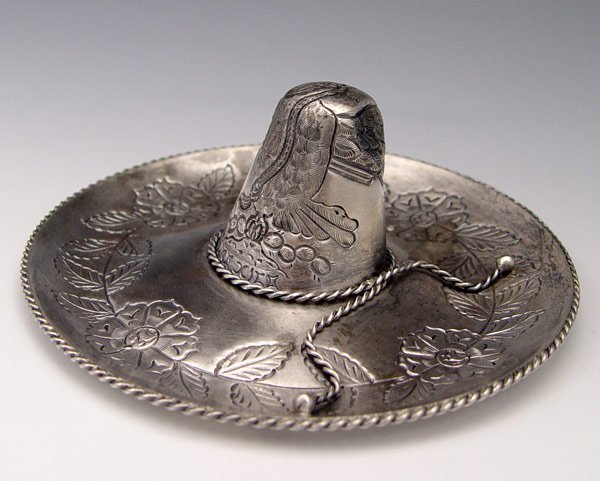 WILLIAM SPRATLING / CONQUISTADOR MEXICAN SILVER H: WILLIAM SPRATLING / CONQUISTADOR MEXICAN SILVER HAT: Early 1950's embossed and engraved hat bearing the Conquistador, Eagle 13, and shield hallmarks. Measures 2" h x 5 1/4". Approx. 2.7 troy oz.