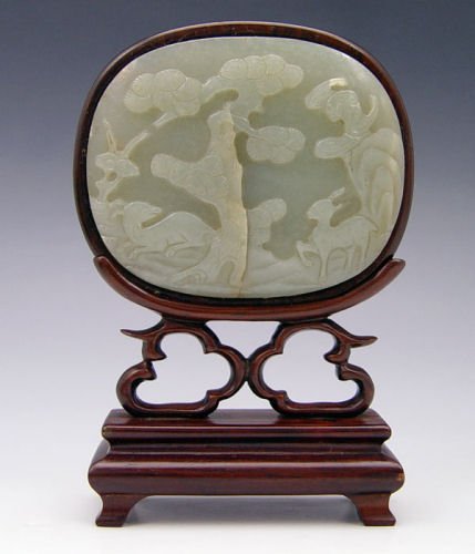 CHINESE MOSS JADE PLAQUE 3 X 3 : CHINESE MOSS JADE PLAQUE FRAMED IN ROSEWOOD: Carved in longevity and good fortune motifs including bats, spotted stag, magic fungus and pine trees. Accompanied by the rosewood stand. Plaque is 3 1/4" 