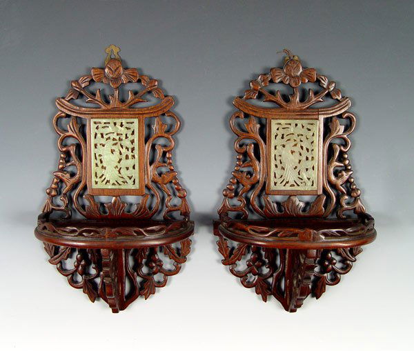 CHINESE PAIR CARVED WALL BRACKETS W/ JADE INSERTS: PAIR CHINESE CARVED WALL BRACKETS WITH JADE INSERTS: Pierce carved rosewood wall shelves in a floral motif set with birds pierce carved in jade? plaques. 13" x 8" x approx. 4 1/2".