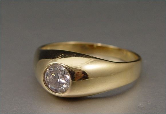 MAN'S 14K DIAMOND SOLITAIRE RING 5.2 Grams Size: 14K yellow gold ring contains one round brilliant cut diamond. Weight: .63 Ct. Approx. Rated SI2 in clarity and J in color. The diamond is gypsy set. Weight: 5.2 grams. Size: 11