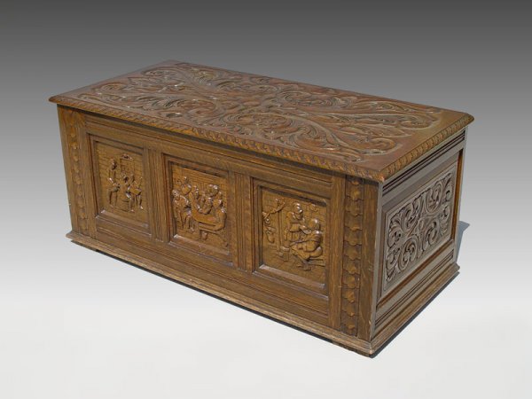 CARVED OAK BLANKET CHEST: CARVED OAK BLANKET CHEST: German tavern scenes in recessed panels, scrolls and leaf pattern carved on the hinged top. 18 1/2"h. x 42" x 19".