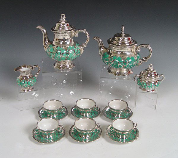 HUTSCHENREUTHER HOHENBERG SILVER OVERLAY: HUTSCHENREUTHER HOHENBERG SILVER OVERLAY COFFEE AND TEA SERVICE: Heavy silver over fine porcelain. The set is comprised of coffee pot (8 1/2"), teapot (7 1/2"), creamer , covered sugar and 6 cups and