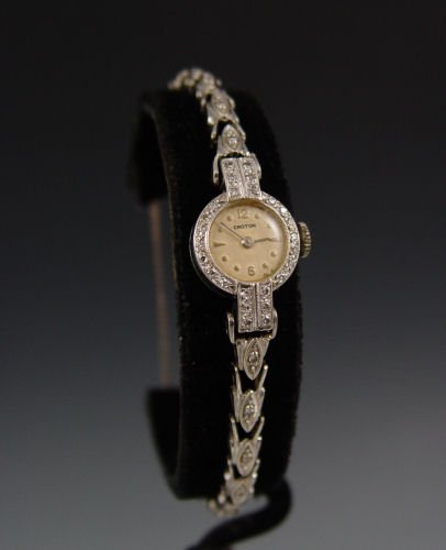 1950's 14K LADIES CROTON WATCH WITH DIAMONDS: 14K LADIES CROTON WATCH WITH DIAMONDS CA. 1950: 14K gold wristwatch, 17 jewel Swiss made movement. Approx. .50 ctw diamonds. Ladder style clasp with safety clasp. Weight 15.1 grams.