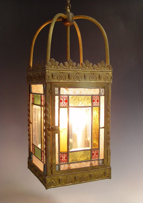 LEADED GLASS HANGING LAMP: LEADED GLASS HANGING LAMP: Pressed brass with geometric panel glass inserts and glass panel base. 4 socket. Measures 22" h. excluding chain x 8 1/2" square.