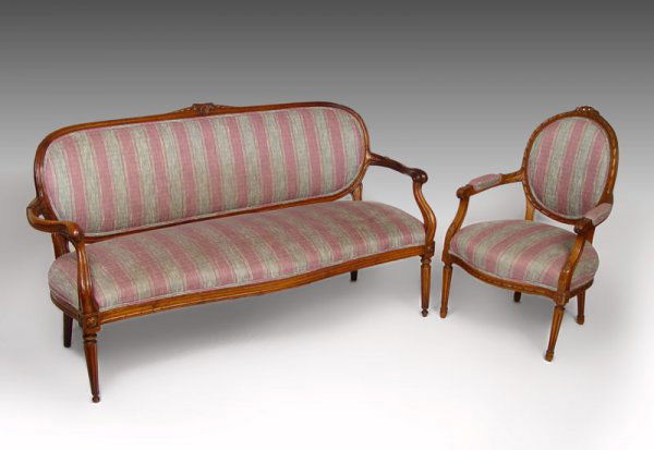 LOUIS XVI CARVED WALNUT SETTEE & CHAIR: LOUIS XVI CARVED WALNUT SETTEE & CHAIR: Walnut open arm settee with gracefully carved arms and supports. Straight reeded legs, pegged construction, later upholstery, 35"h. x 66" length x 26" deep. The