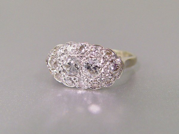 14K DIAMOND CLUSTER RING: DIAMOND CLUSTER RING: 14K white gold ring contains two old European round cut diamonds (one diamond is chipped) and twelve old mine cut, Swiss cut and single cut diamonds. Approx. .75 Ct. The diamonds