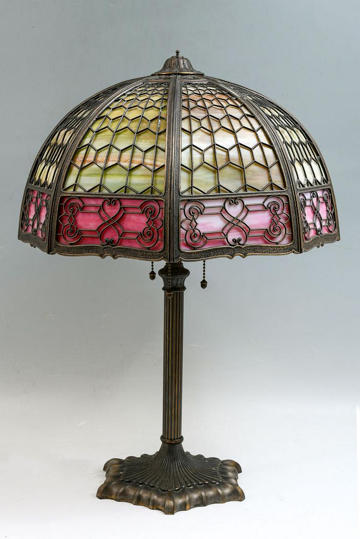 MILLER ART DECO SLAG GLASS LAMP: MILLER ART DECO SLAG GLASS LAMP: Filigree slag glass lamp shade, having a geometrical design with scrolling lower border. Ribbed art deco 3 light base with Acorn form pulls. Lamp signed ''Miller'', ''