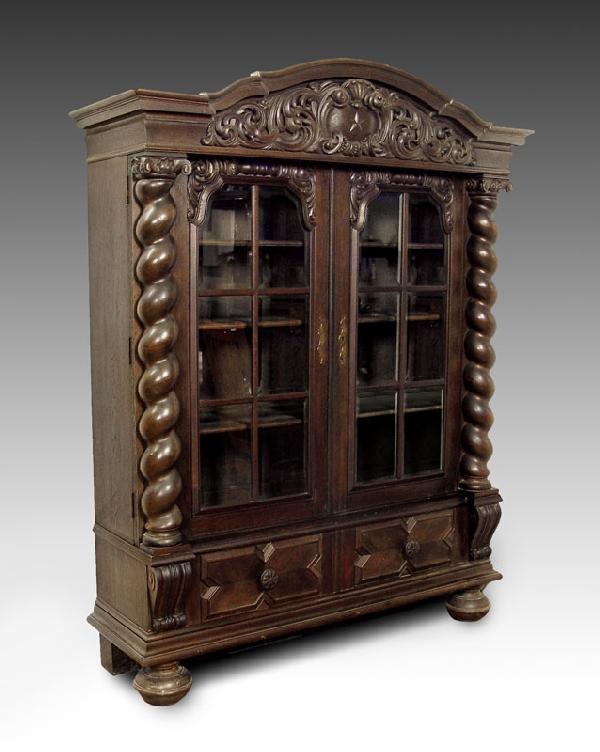19th C ALSACE LORRAINE CARVED BOOKCASE: 19TH C ALSACE LORRAINE CARVED BOOKCASE: Massive dark oak glass door bookcase. 12 light beveled glass doors. Interior with shelves. Twisted columnar front with capitals, heavy carved cornice centering 