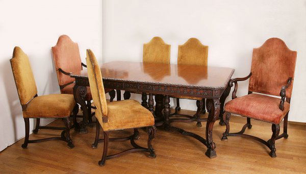 CARVED DINING TABLE AND CHAIRS: LATE 20TH C. HEAVILY CARVED ITALIAN STYLE TABLE WITH 6 UPHOLSTERED CHAIRS: The table with curved stretchers joining at a four column base. 30'' tall x 74'' wide x 46''. Two arm chairs, four side with