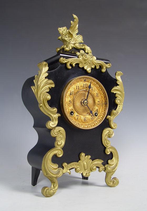 ANSONIA CAST IRON SHELF CLOCK: ANSONIA CAST IRON SHELF CLOCK: Cast iron body with ormolu style applied decoration. Metal face with Arabic numeral. Ansonia time & strike movement. 18" h. x 10 1/4" x 5 1/2". Key & pendulum in office.