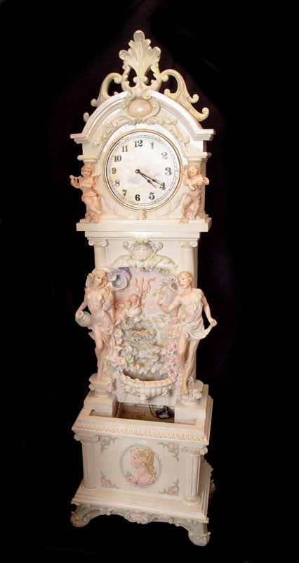 MOLDED ROCOCO GRANDFATHER WATERFALL CLOCK CHERUBS: MOLDED ROCOCO GRANDFATHER WATERFALL CLOCK WITH CHERUBS: Molded resin or plastic grandfather clock featuring cherubs, Greek figures and stunning water feature with multi colored strobing lights. Electr