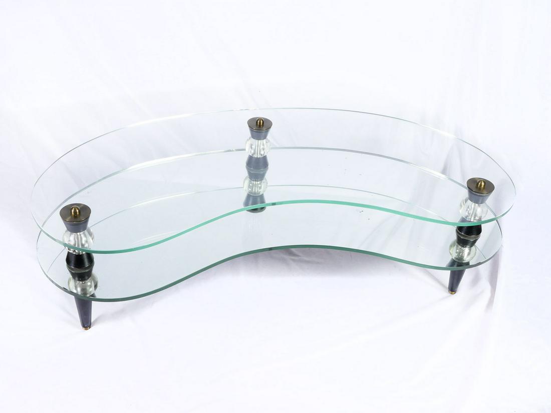 1956 SEMON BACHE, NEW YORK KIDNEY SHAPE TABLE: 1956 SEMON BACHE, NEW YORK KIDNEY SHAPE TABLE: Mid-century modern kidney shaped coffee table, having a lower mirrored shelf below glass top. Raised on tapered round legs with brass ball feet. Approx. 