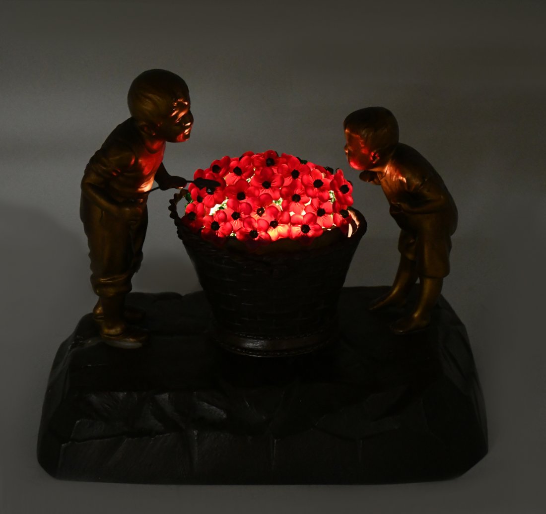 CZECH BRONZE FIGURAL & ART GLASS FLORAL BASKET LAMP: CZECH BRONZE FIGURAL & ART GLASS FLORAL BASKET LAMP: Central basket form lamp, surmounted by a floral art glass shade. Flanked by two young boys, one with a fly swatter resting in hand. All on a rock 