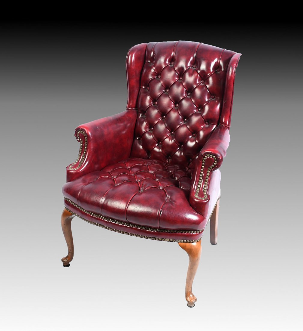 RED LEATHER CHESTERFIELD CHAIR: RED LEATHER CHESTERFIELD CHAIR: Oxblood red leather wing back chair with button tufted back rest & cushion. Raised on front cabriole legs with Dutch Club feet. Approx. 38.75" h x 27.75" l x 30.75" w.