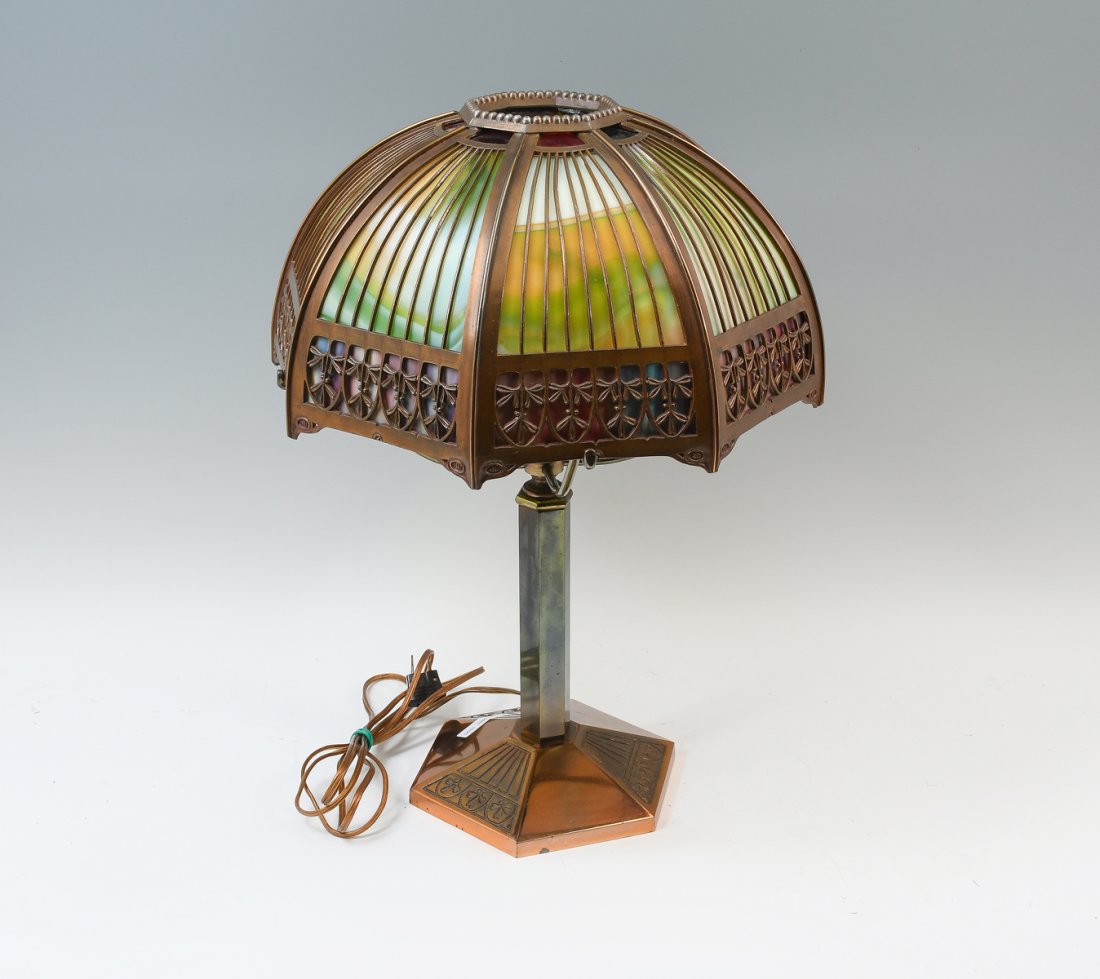 BRADLEY & HUBBARD SLAG GLASS LAMP: BRADLEY & HUBBARD SLAG GLASS LAMP: Octagonal stained glass shade with a filigree foliate lower border. Resting on a 4 armed shade support. Hexagonal copper toned base. "B&H, 219", in casting at unders