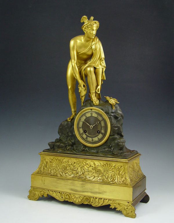 FRENCH FIGURAL MERCURY CLOCK: FRENCH FIGURAL MERCURY CLOCK: Mixed metal brass and bronze with gilded figure of Mercury and staff on top. Metal mace with Roman numerals. French time and strike movement marked AB 156. Key and pendul