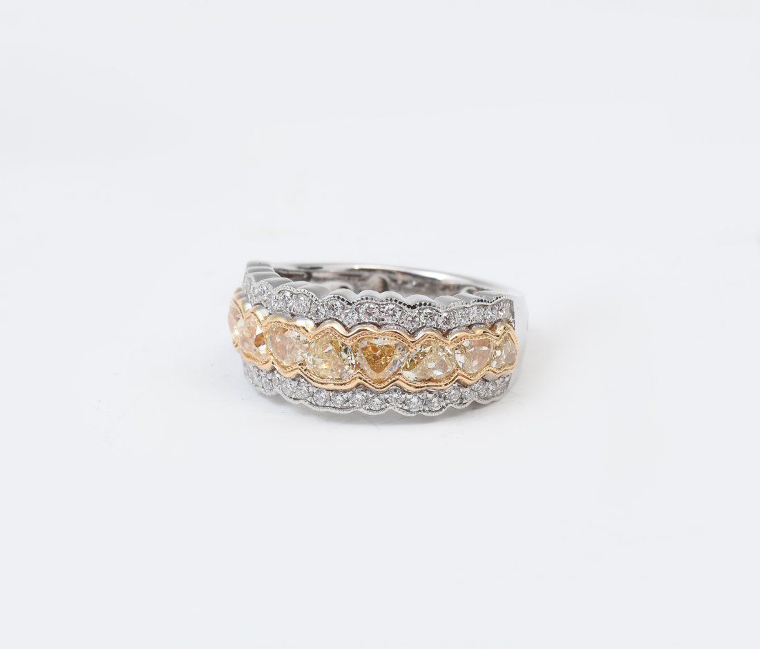18K 2.22 CTW FANCY YELLOW DIAMOND RING: 18K 2.22 CTW FANCY YELLOW DIAMOND RING: 9 modified brilliant cut fancy yellow diamonds are set horizontally in 18K with 44 brilliant cut diamonds set horizontally bordering the yellow diamonds on the 