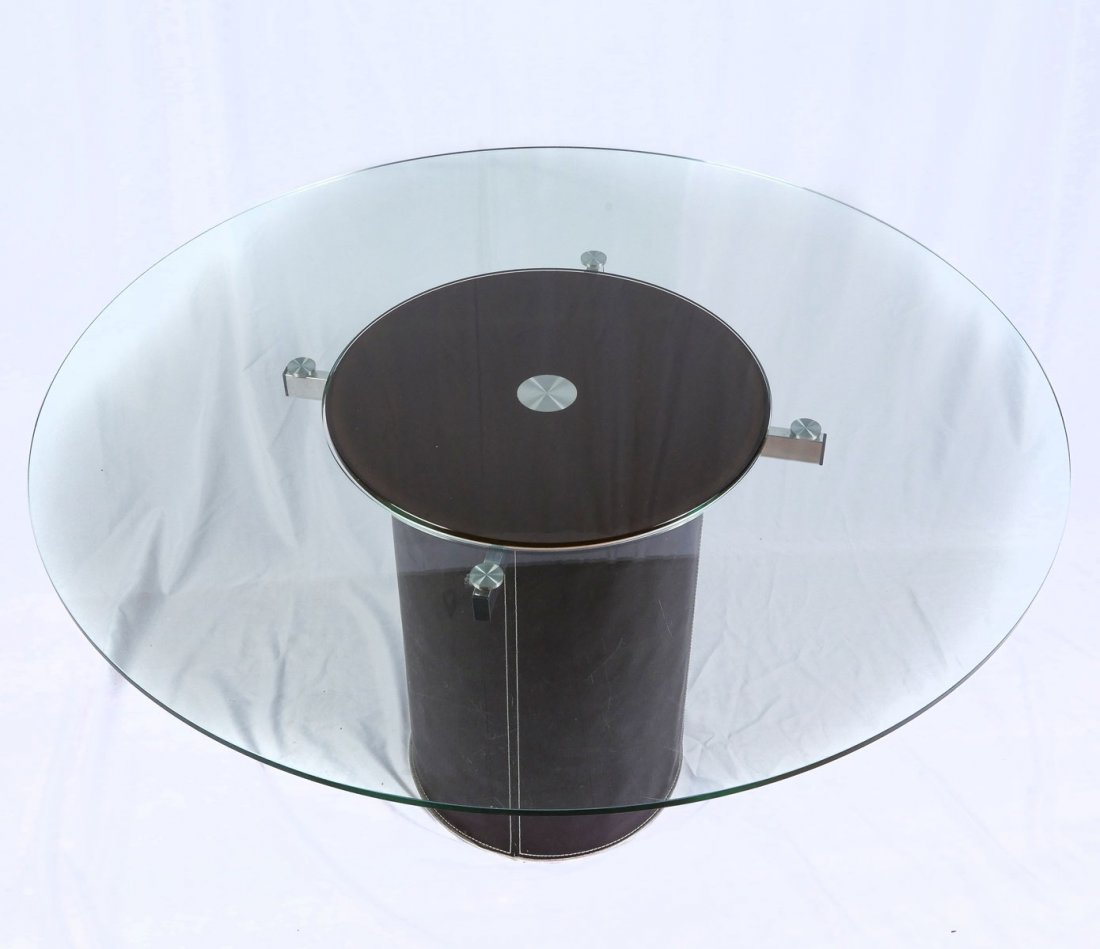 MODERN GLASS & LEATHER TABLE: MODERN GLASS & LEATHER TABLE: Modern glass top table, having a central raised lazy Susan in center. Base wrapped in leather. Approx. 30.25" h x 54" dia. Lazy Susan Approx. 23.5" dia.