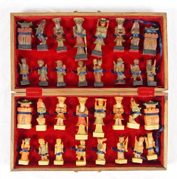 CARVED WOOD CHINESE CHESS SET IN CASE: AN UNUSUAL CARVED WOOD CHINESE FIGURAL CHESS SET IN CASE: Polychrome carved wood pieces, complete set. King measures 4 1/2" h.. Comes in case with parquetry inlay board. Case measures 4" x 16 3/4" x 8