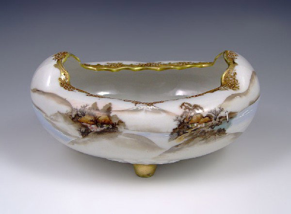 NIPPON HAND PAINTED BOWL: UNUSUALLY SHAPED NIPPON HAND PAINTED BOWL: Hand painted landscape with water scene, gilt and beaded design on rolled edges. 4''h. x 8 1/2''l.