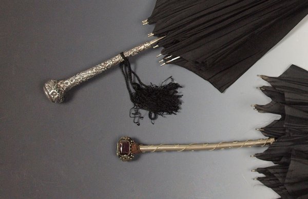 STERLING REPOUSSE UMBRELLA & EXTRA : 2 LATE VICTORIA UMBRELLAS, ONE WITH STERLING REPOUSSE HANDLE: 1) Ornate sterling repousse handle bears the hallmarks of Ritter & Sullivan (silversmith) and Harris & Shafer (retailers). The handle is 8