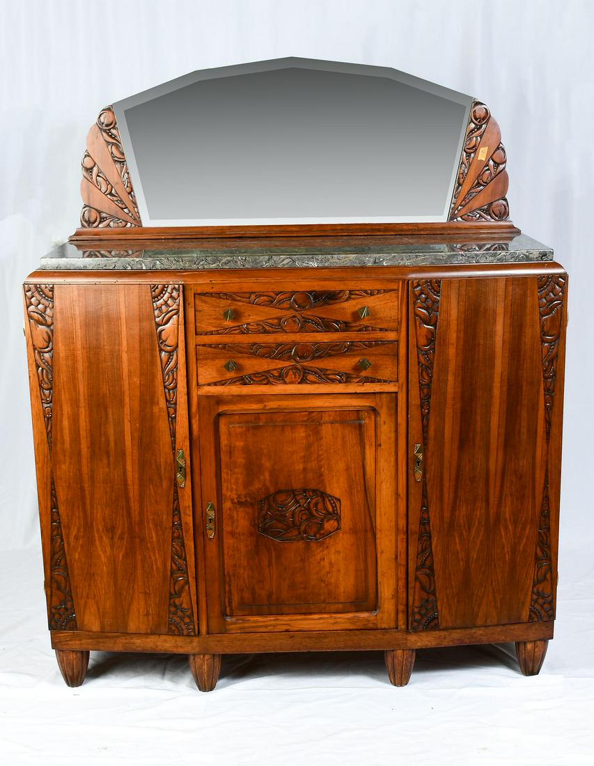 CARVED ART DECO BUFFET: CARVED ART DECO BUFFET: Surmounting beveled mirror and gray marble top, resting on a 2 drawer, 3 door buffet, having a carved stylized fruit & foliate motif. Raised on ribbed tapered feet. Approx. 63"