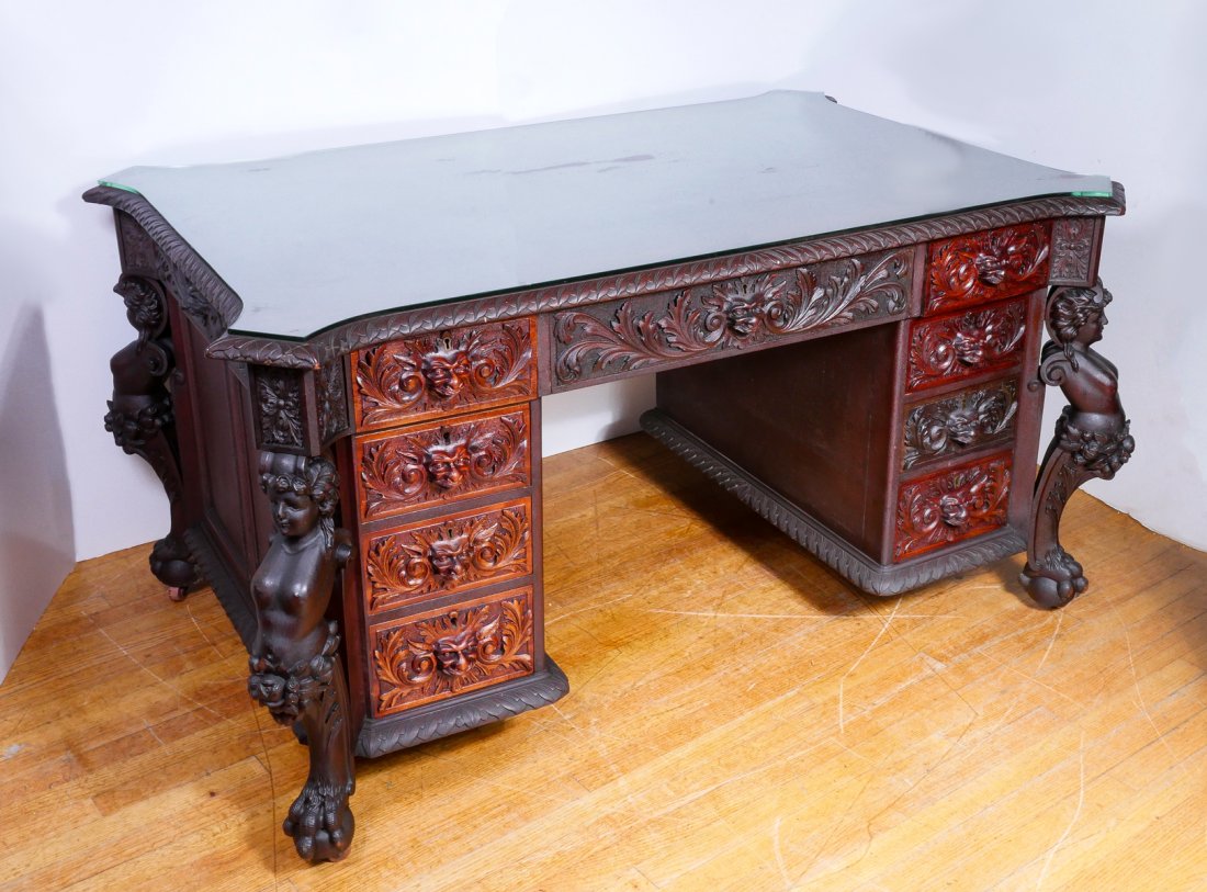 RJ HORNER CARVED MAHOGANY PARTNERS DESK: RJ HORNER CARVED MAHOGANY PARTNERS DESK: Form fitting glass top resting on an elaborately carved Mahogany partners desk, having 9-drawers each, at the observe & the reverse. Drawers carved with Greenm