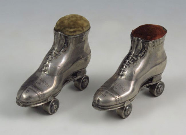 WHIMSICAL SILVER ROLLER SKATE FIGURAL PIN CUSHIONS: WHIMSICAL EDWARDIAN SILVER ROLLER SKATE FIGURAL PIN CUSHIONS: Bear the hallmarks for Crisford & Norris, 1909 Birmingham. Strand Lodge 1987 1910 impressed on each. 2"h. x 2 3/4".