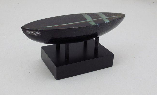 VALLIEN FOR KOSTA BODA ATELIER: VALLIEN FOR KOSTA BODA ATELIER: Swedish crystal, signed and numbered. Boat form with interior strokes of color. Rests on a wooden stand. Glass is 6 3/4"long x 1 1/2"h.