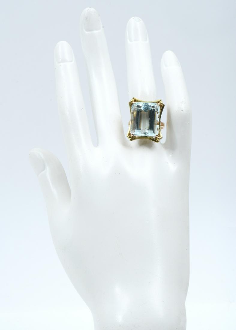 VINTAGE 18K 18.8 CT AQUAMARINE RING: VINTAGE 18K 18.8 CT AQUAMARINE RING: Wonderful 18.8 CT aquamarine is prong set within a curved, florentined 18K yellow gold frame. Rated VVS in clarity, gB in Hue 2 in tone and 2 in Saturation. Size 7