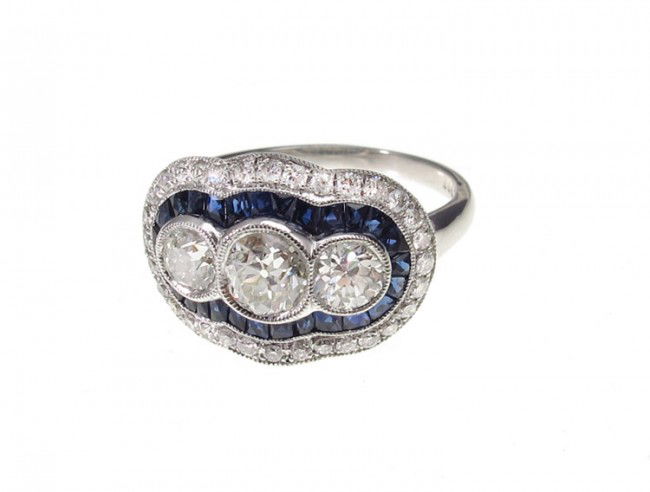 PLATINUM ART DECO REVIVAL DIAMOND & SAPPHIRE RING: SOPHIA D PLATINUM ART DECO REVIVAL RING: Diamonds and sapphires. The platinum ring centers 2 old European and 1 round brilliant diamonds framed by 32 round brilliant cut diamonds. Total diamond weight