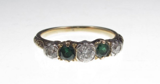 14K DIAMOND BAND RING CA. 1920s: 14K yellow gold ring contains three old European round cut diamonds. Weight: .33 Ct. Approx. Rated VS in clarity and H-I in color. Two 2.50 mm green stones of unknown origin. The stones are prong set.