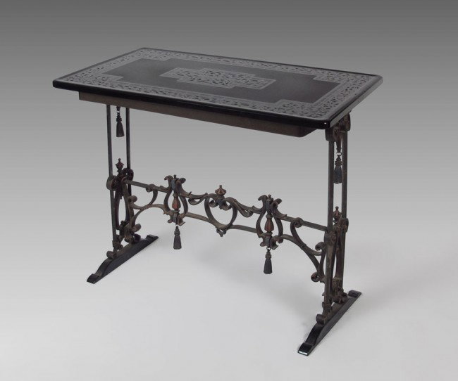 ETCHED GLASS TOP IRON BASE TABLE: Oscar Bach era iron table with ornate sides and stretcher embellished with iron tassels. Slight remains of the polychrome finish. The thick glass top is etched a stylized design. Approx. 30" tall x 36