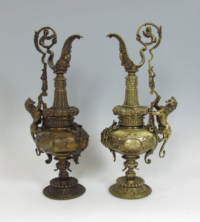 PAIR 19TH C BRONZE EWERS: PAIR 19TH C BRONZE EWERS: Highly ornamental with lions "climbing" the side. Winged cherub on the handles, 25 1/4" tall.